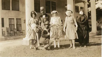 Masked and costumed Halloween party guests on a porch, vintage snapshot