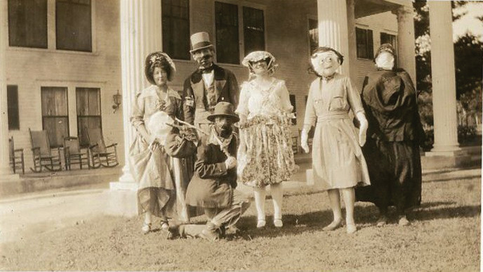 Masked and costumed Halloween party guests on a porch, vintage snapshot, c. 1917 — historic photograph