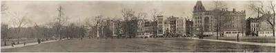 Panoramic photograph of a city park with street buildings, c. 1910