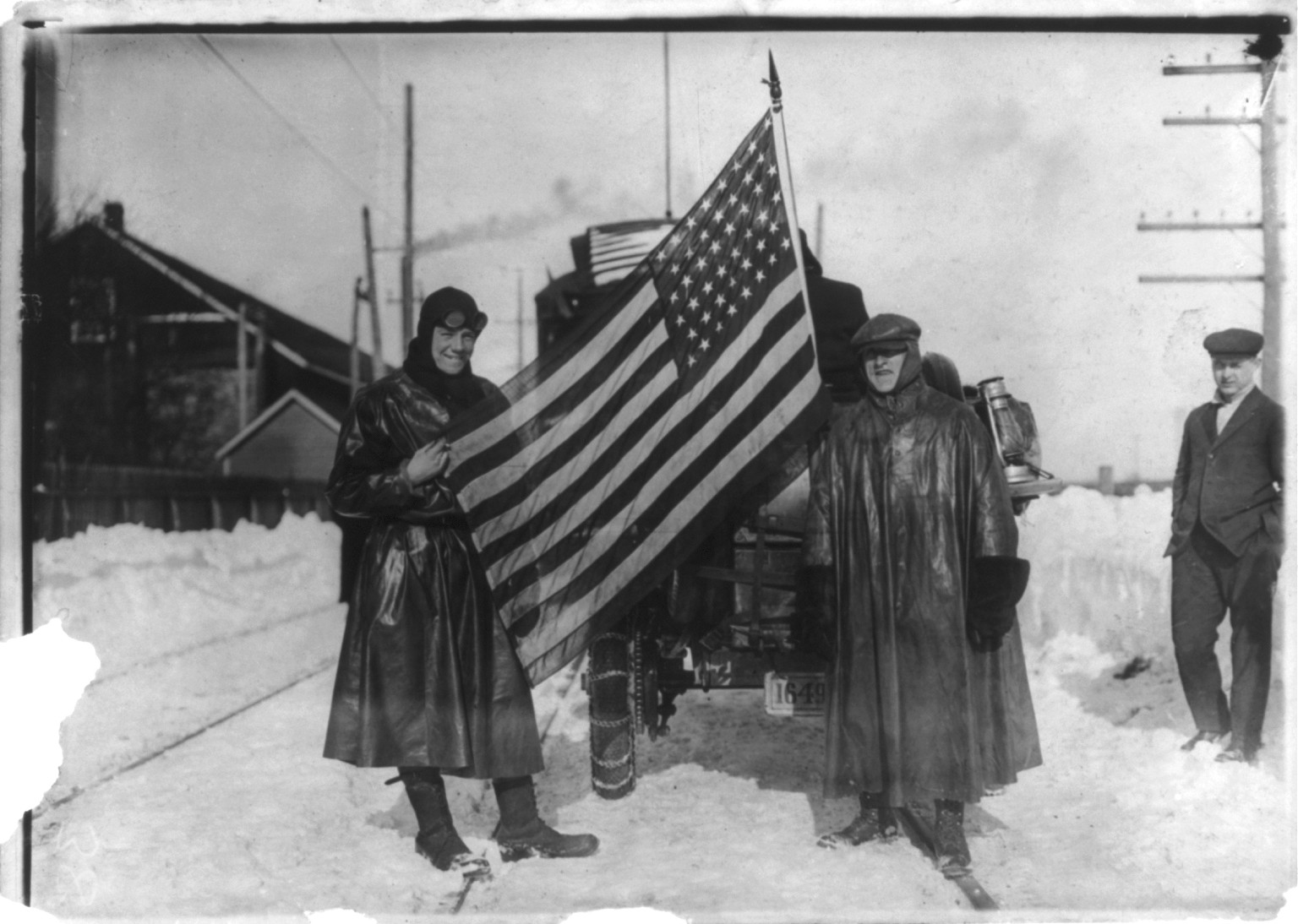New York-to-Paris automobile race: [Two men holding U.S. flag behind automobile], [1908?] — historic photograph