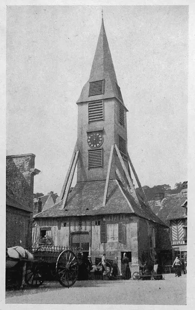 Timber-framed market belfry with clock and spire, horse cart in foreground