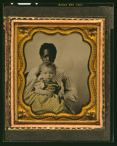 [African American woman holding a white child]