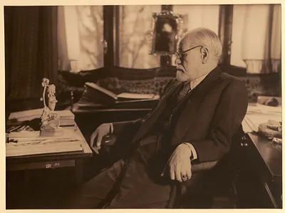 Bearded elderly man with glasses seated in a study