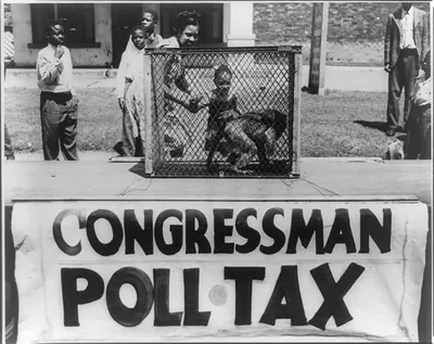 [Caged monkey on platform with sign reading Congressman Poll Tax" displayed by the NAACP Detroit branch during their "Parade for Victory" march]"