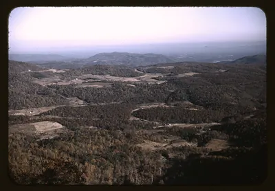 Forested mountain valley with winding roads seen from overlook