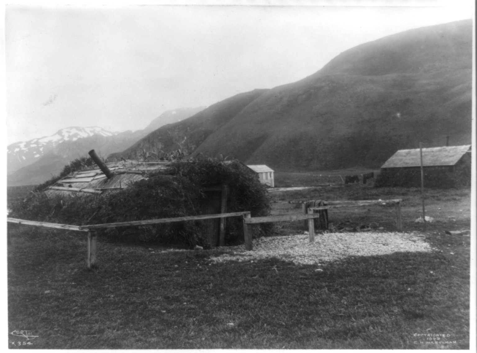 [Aleutian Islands? : Earthen hut with fence], c1899. — historic photograph