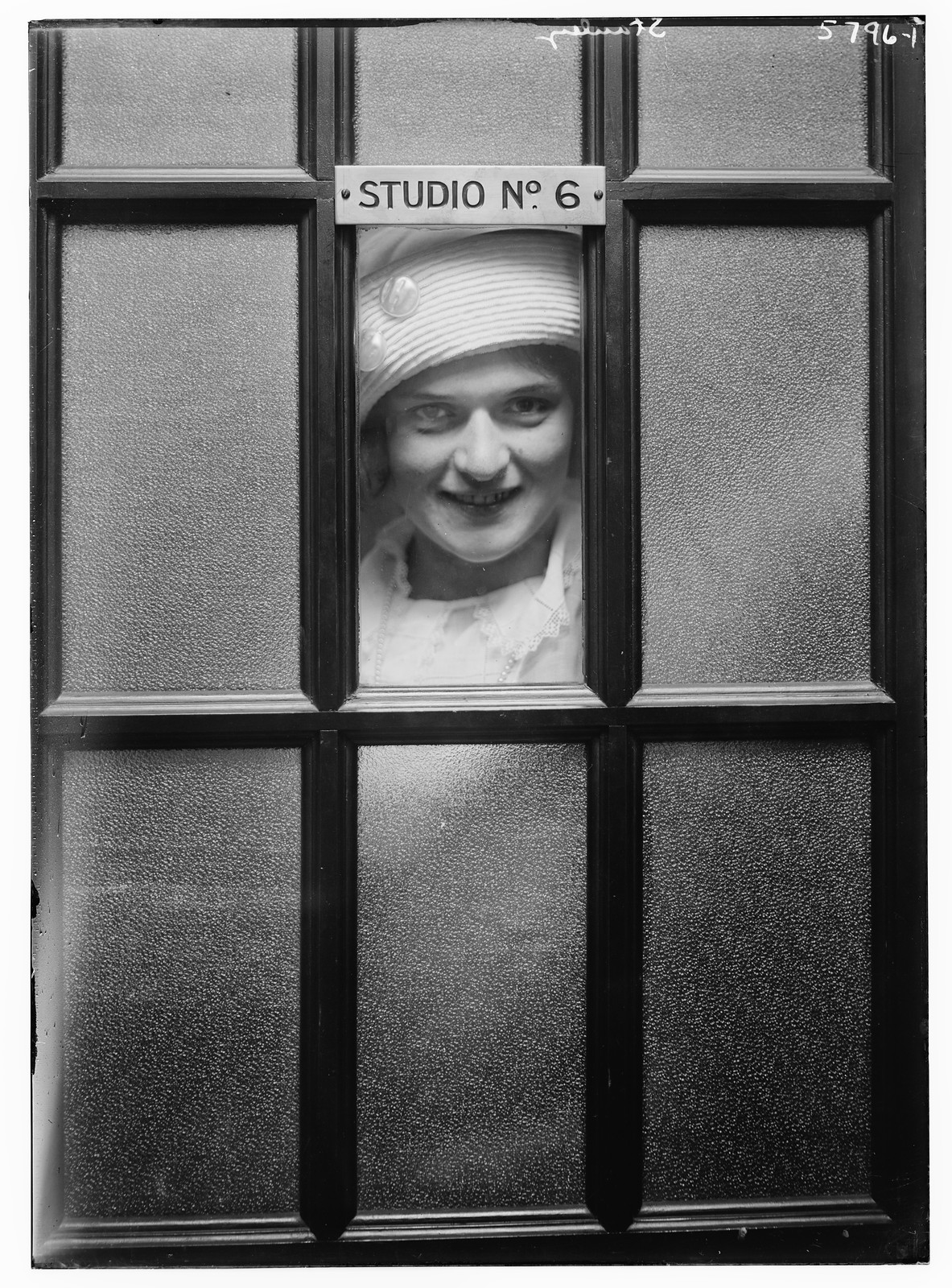 Stanley looking out of window, of studio 6, n/a — historic photograph