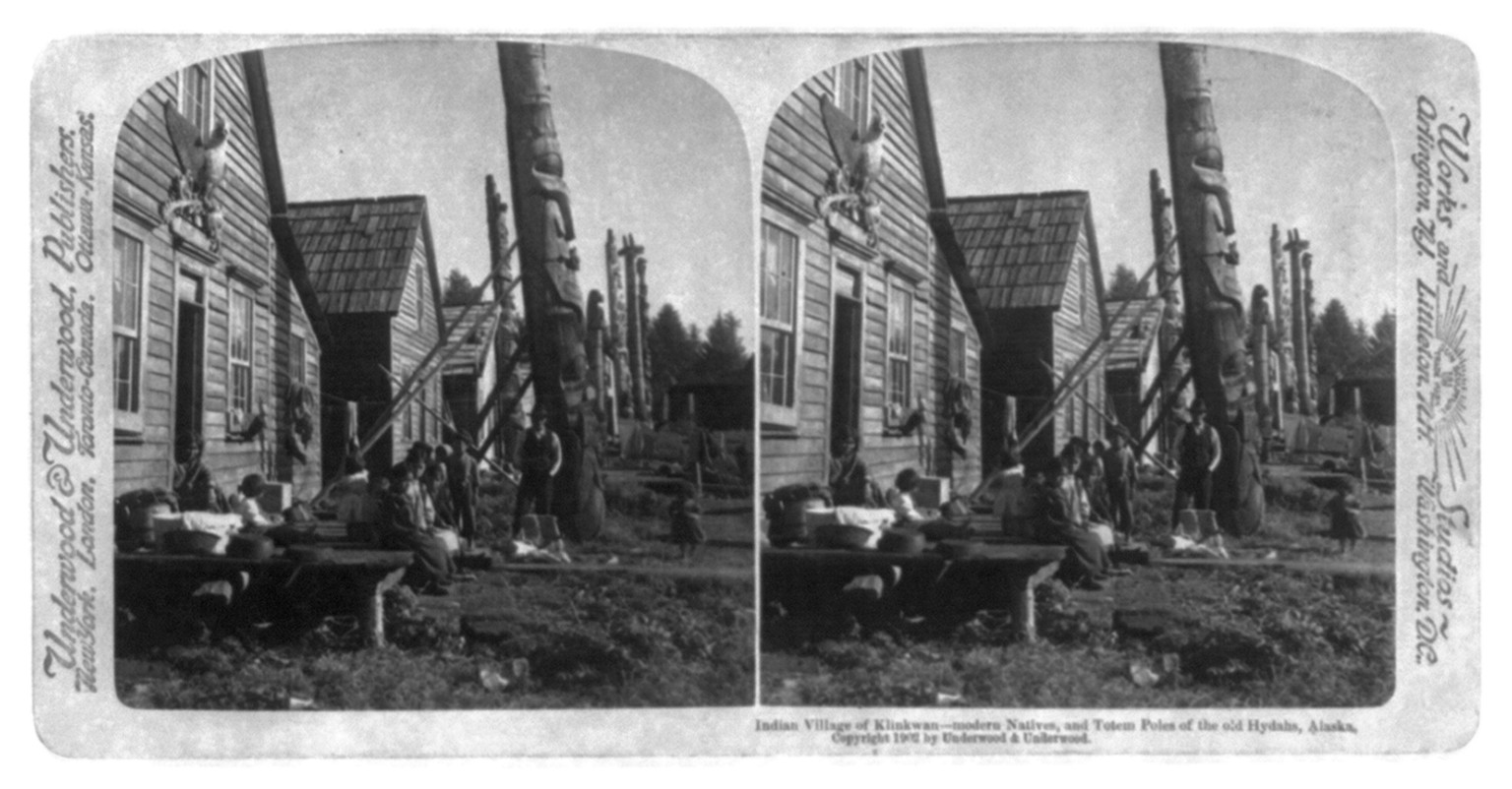 Indian Village of Klinkwan - modern Natives and Totem Poles of the old Hydahs [i.e. Haida], Alaska, c1902. — historic photograph