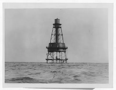 Offshore lighthouse on iron framework rising from open sea