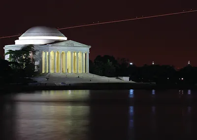 Jefferson Memorial at night, lit columns above reflecting water