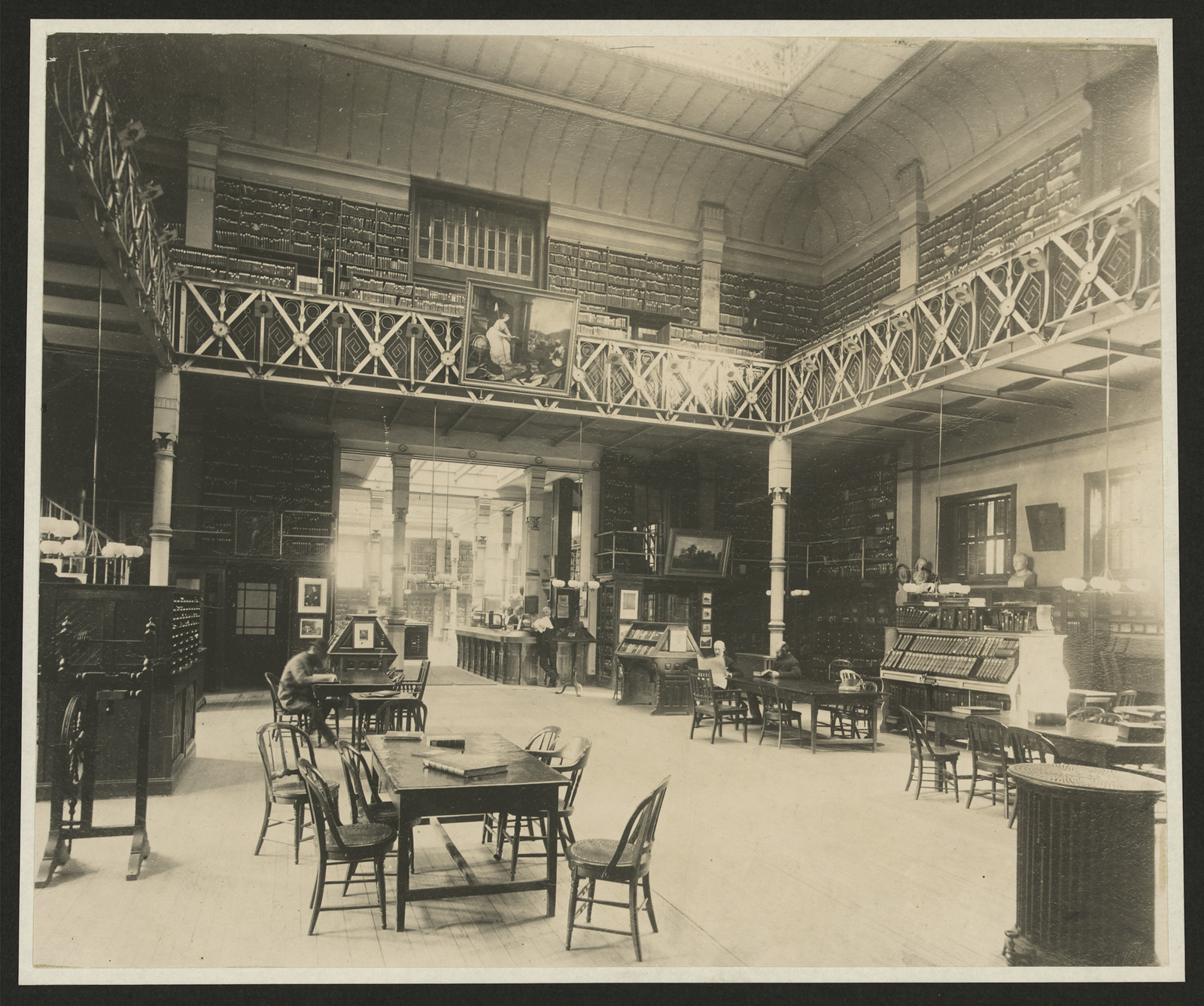 Library reading room with tables, chairs and card catalog cabinets — historic image