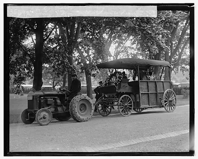 Tractor towing a horse-drawn funeral wagon with wreaths