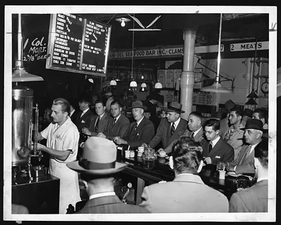 Men eating at a seafood bar lunch counter