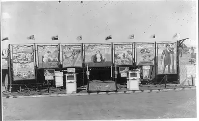 [Entrance to circus freak show, showing ticket booths and large posters. 1925]