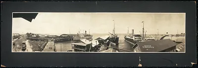 Panoramic harbor view with steamships and pier buildings, circa 1909