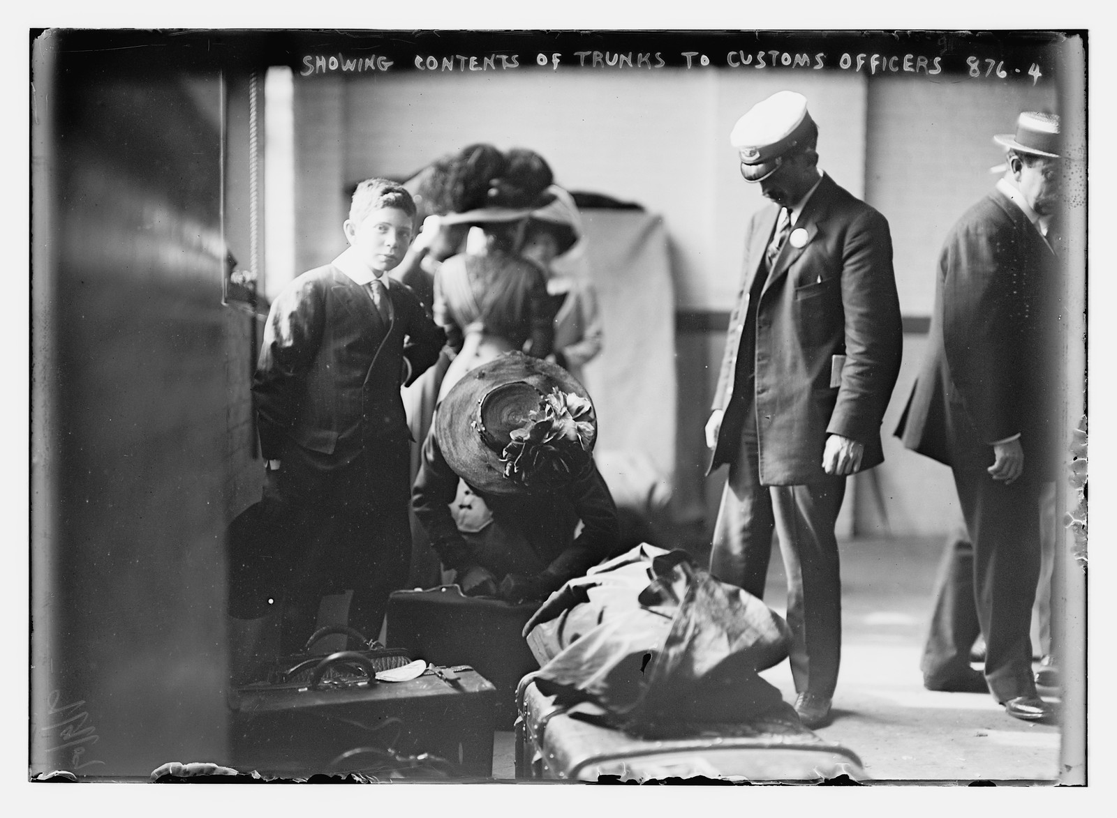 Woman showing baggage contents to customs officer, N.D.L. pier, New York, 9/9/09. — historic photograph