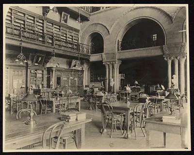 Library reading room with arched windows, galleries and wooden desks