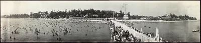Crowded panoramic beach with bathers and pier crowd