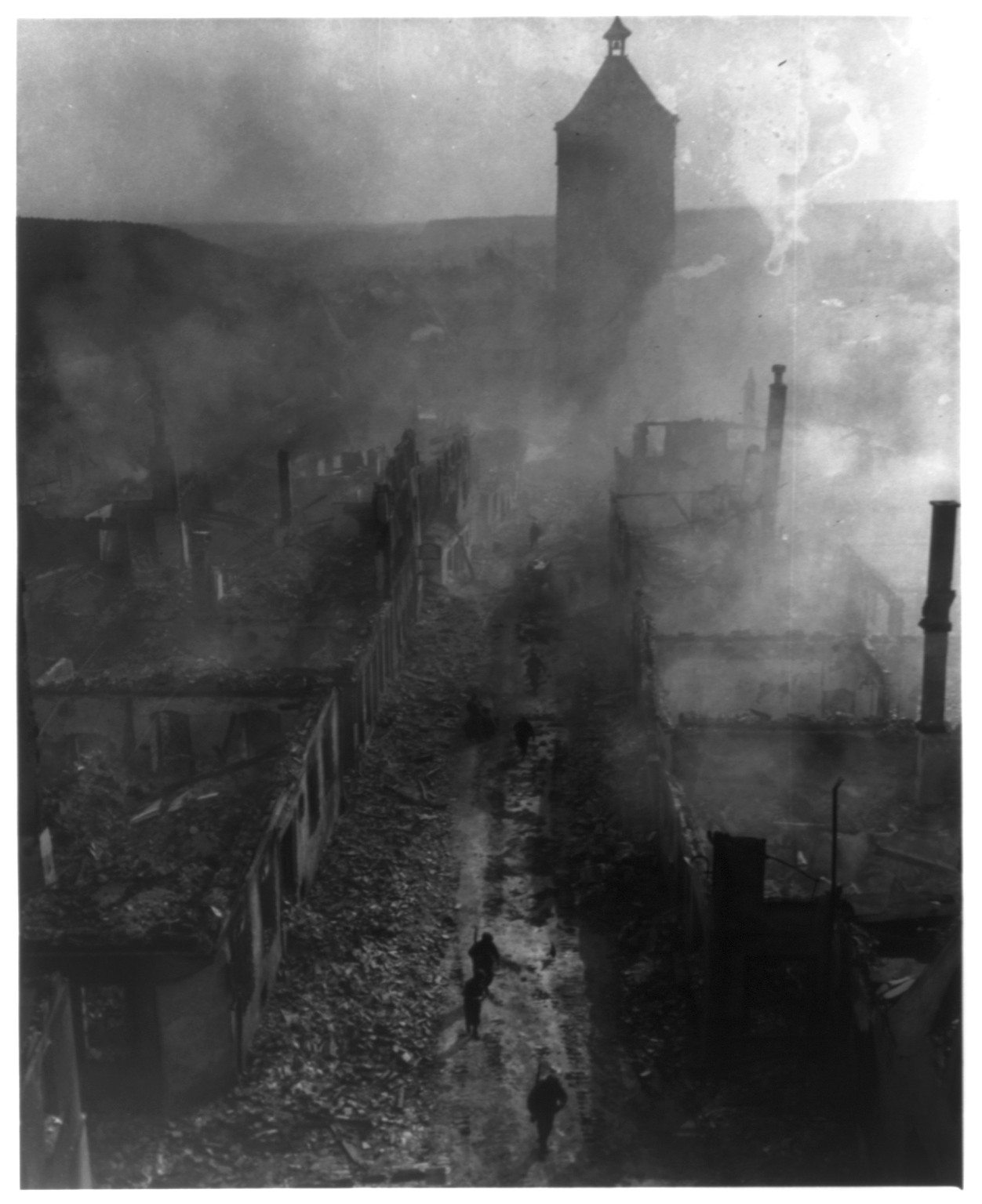 Infantrymen of the 2nd Bn, VI Corps, 255th Inf. Regt., move down a street in Waldenburg to hunt out the Hun after a recent raid by a 63rd Div., US Seventh Army, 1945 April 16. — historic photograph