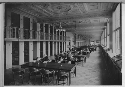 Library reading room with gallery and long wooden tables