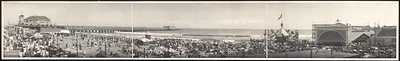 Panoramic view of crowded beach with pier and pavilion