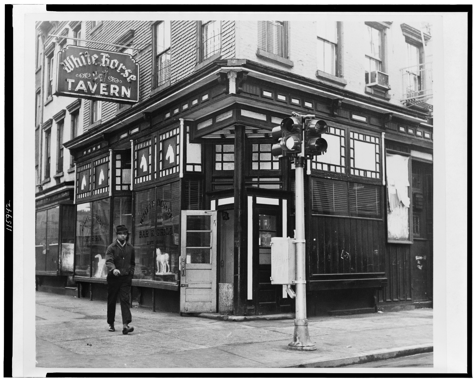 [White horse tavern, exterior view, with African American man walking by] / World Telegram & Sun photo by Phyllis Twachtman., 1961 — historic photograph