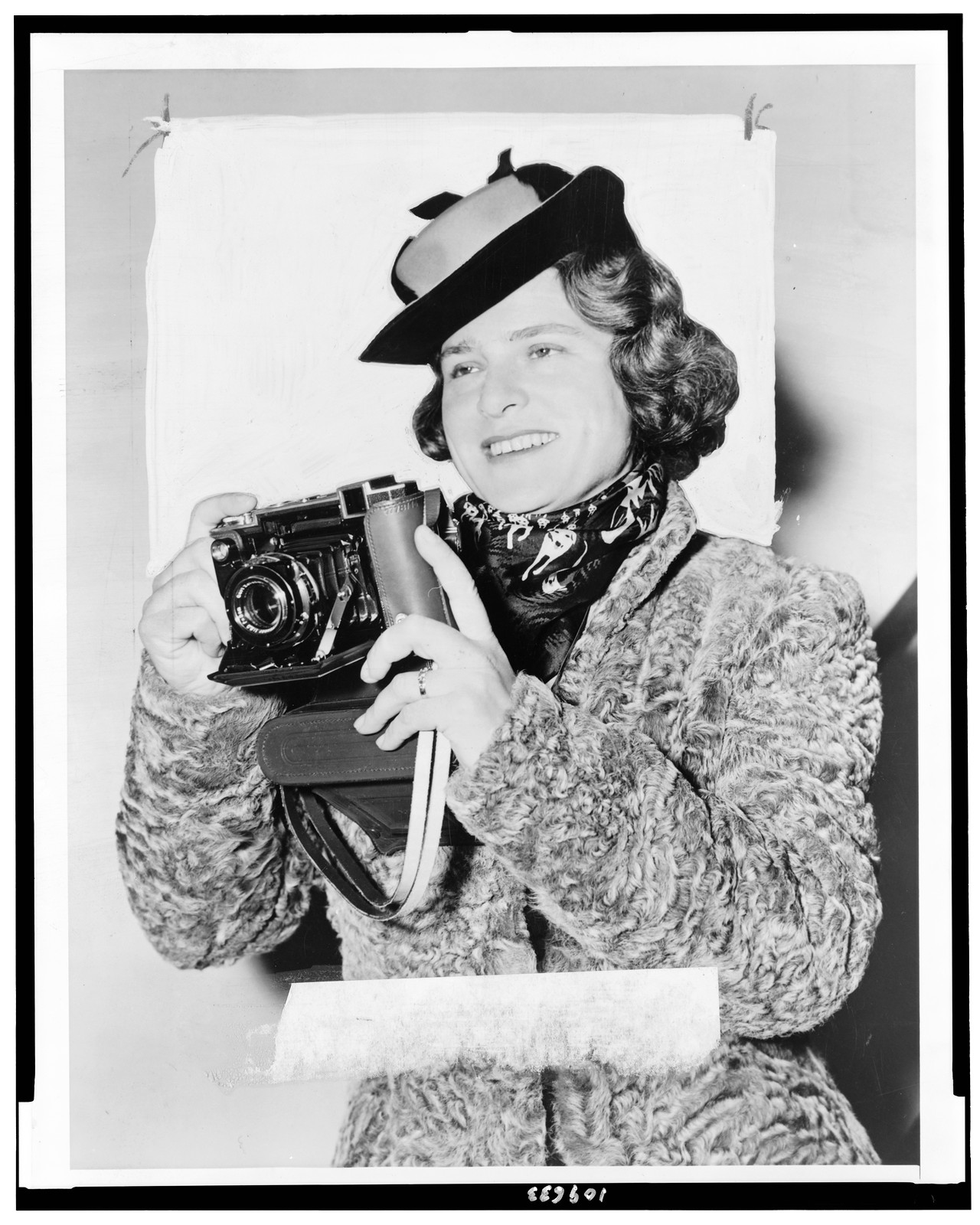 [Margaret Bourke-White, half-length portrait, facing left, holding camera] — historic photograph