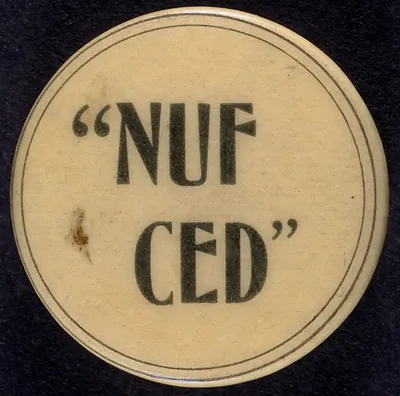Round button reading “NUF CED” on cream background