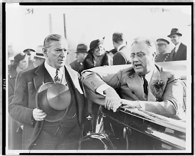 [President Franklin D. Roosevelt, seated in car, turned to the left, talking with Governor James Curley, while on campaign tour in Brockton, Massachusetts]