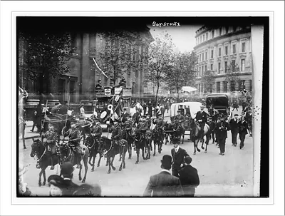 Boy Scouts. Marching on horseback down a street.