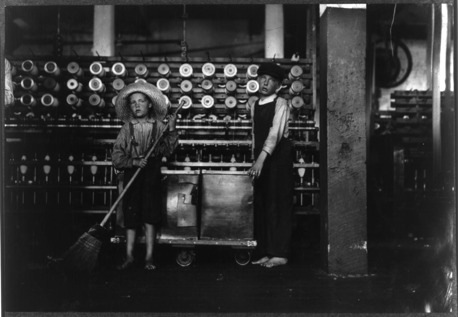 Ronald Webb, twelve year old doffer boy and Frank Robinson, seven year old who helps sweep and doff. Father is cardroom boss, Roanoke (Va.) Cotton Mills. Location: Roanoke, Virginia., 1911 May. — historic photograph