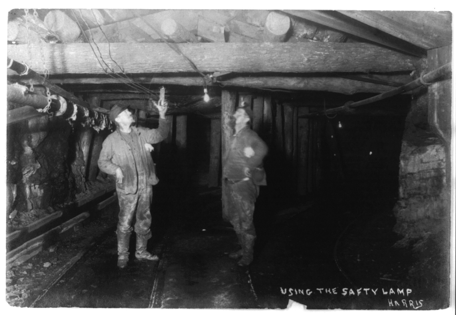 [Men in a coal(?) mine: 2 men using the safety lamp], c1906. — historic photograph