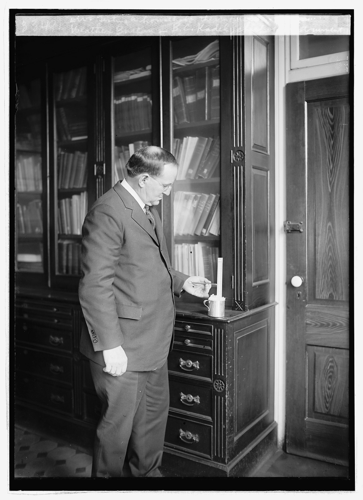 Weather Bureau, B.C. Kadel, Chief of Instrument Div. testing a household thermometer, [ca. 1924] — historic photograph