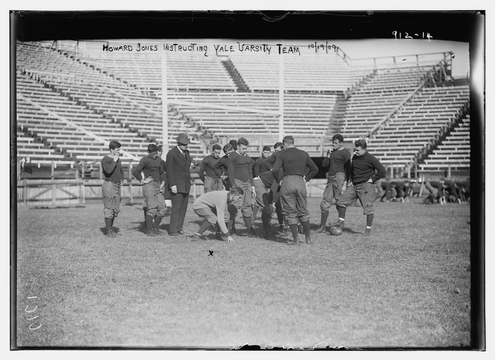 Howard Jones instructing Yale Varsity football team on playing field, New York, 10/19/09. — historic photograph