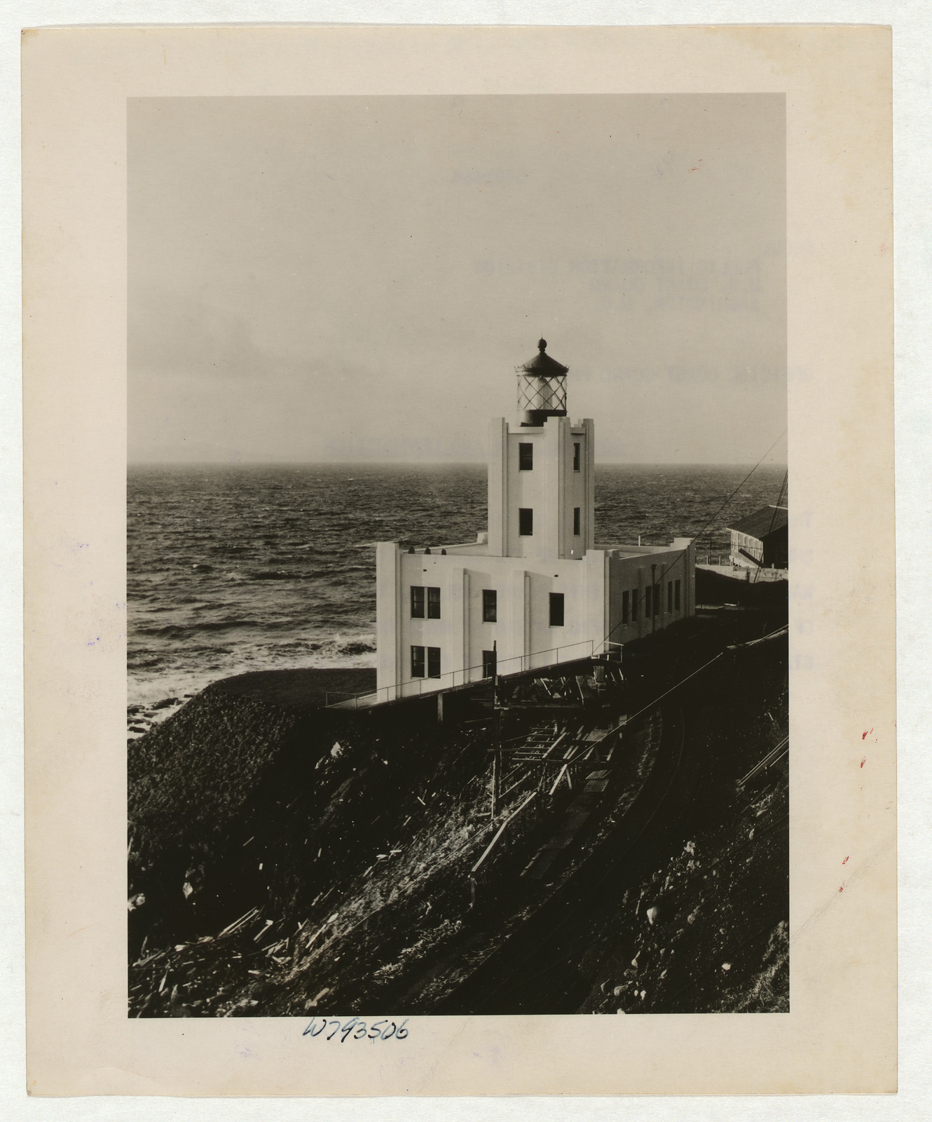 White Art Deco lighthouse on a cliff above the sea — historic image