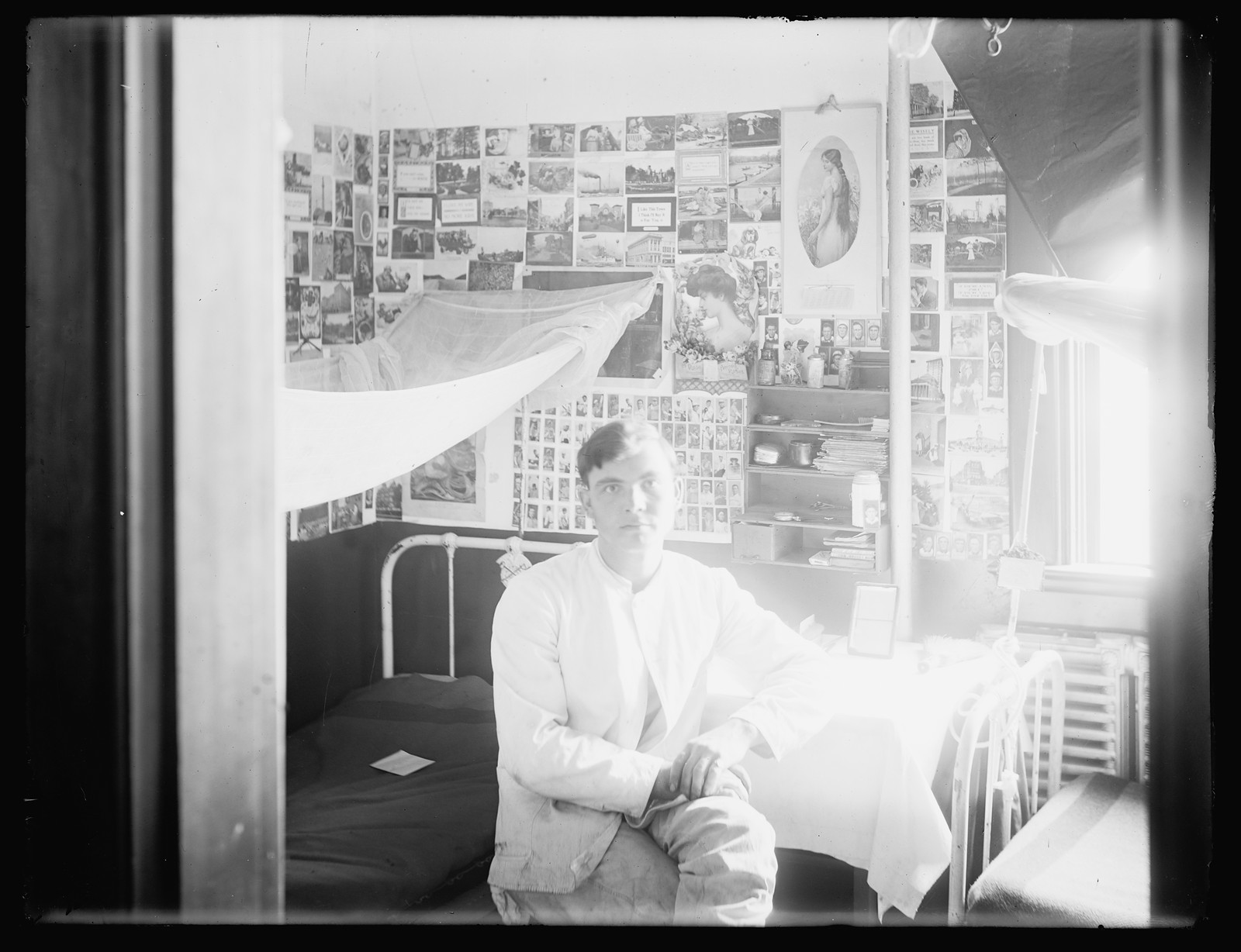 [Young man in dormitory room], [between 1910 and 1920] — historic photograph