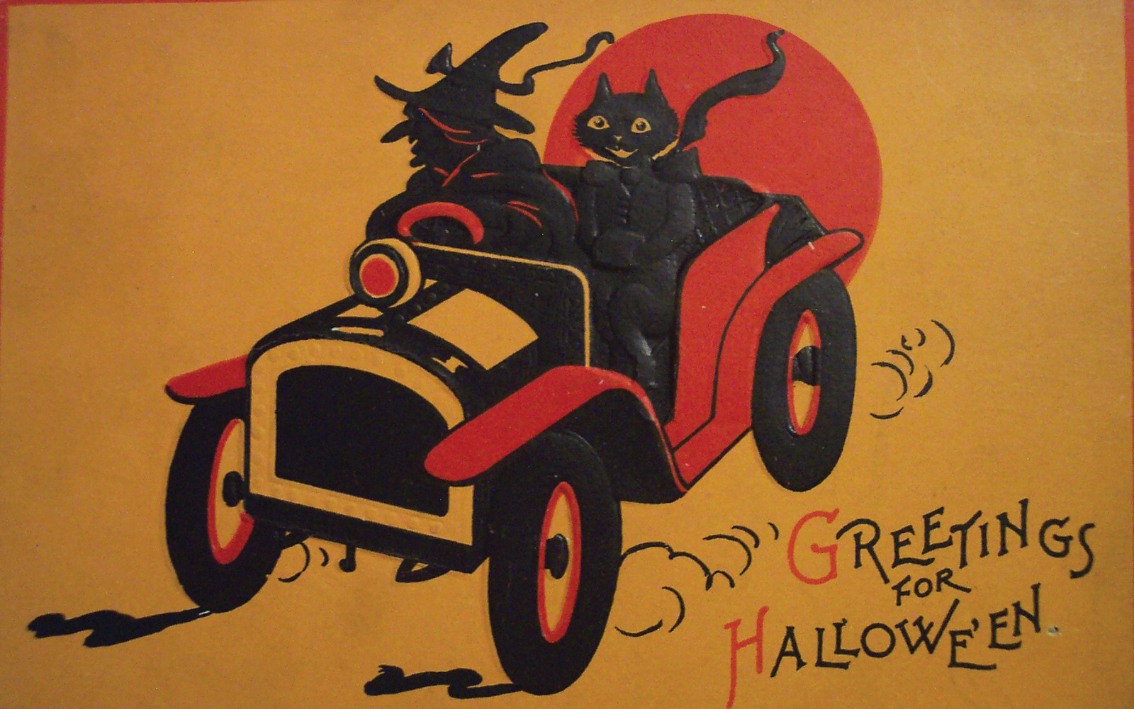 Greetings for Halloween: witch and black cat in car — historic image