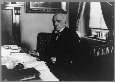 [Leslie M. Shaw, half-length portrait, seated at desk, facing left]