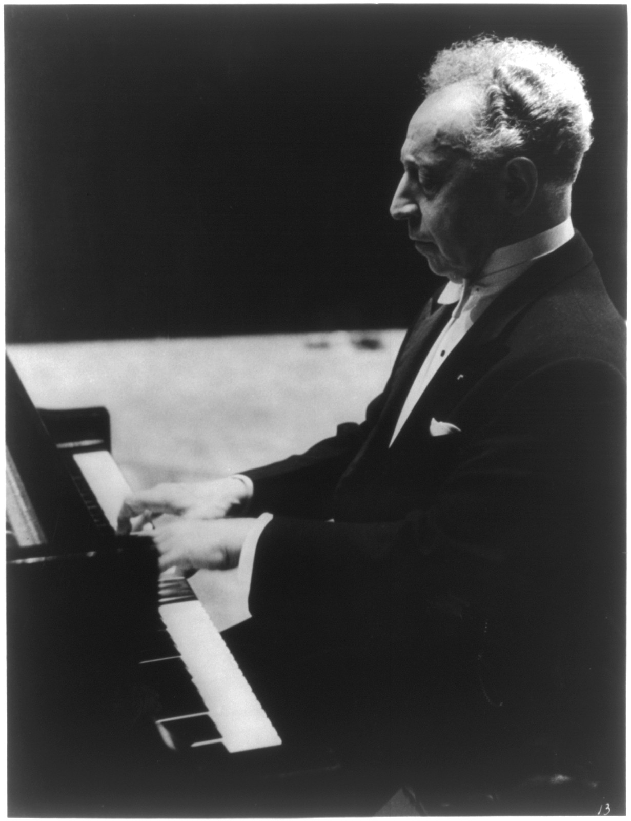 [Arthur Rubinstein, 1886- , half-length portrait, left profile, seated at piano] — historic photograph