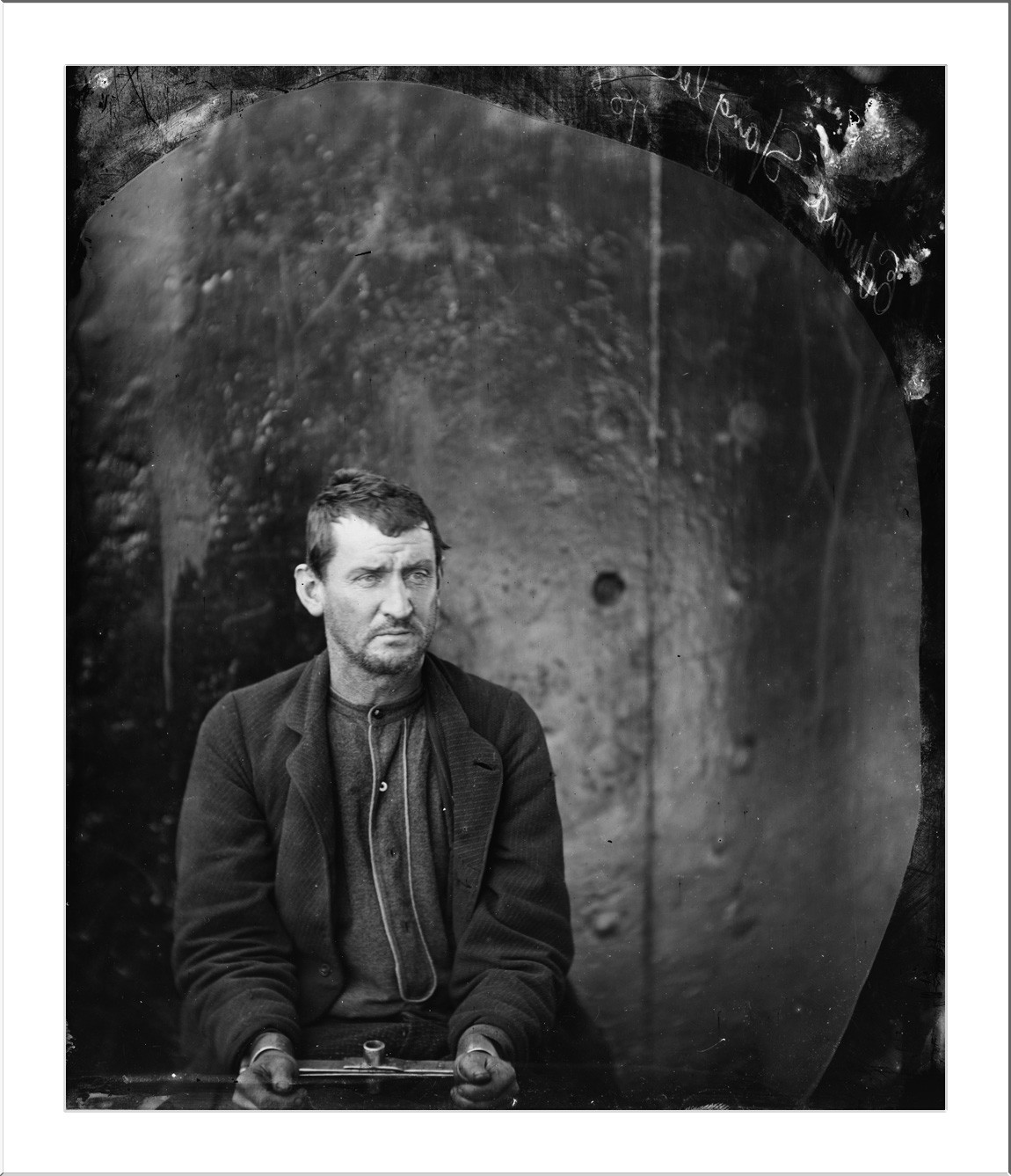 Seated man in shackles, 19th-century glass-plate portrait — historic image