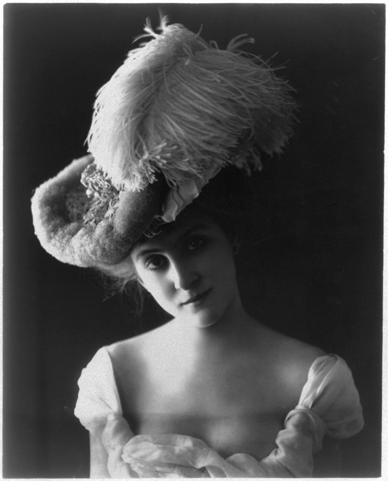 [Young woman modeling: head and shoulders, wearing plumed hat and low-cut dress], [no date recorded on caption card] — historic photograph