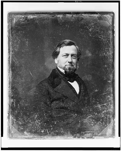 Bearded man in dark coat and bow tie, early photographic portrait