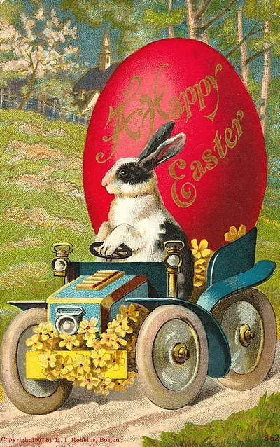 Rabbit driving a motor car beside a red Easter egg