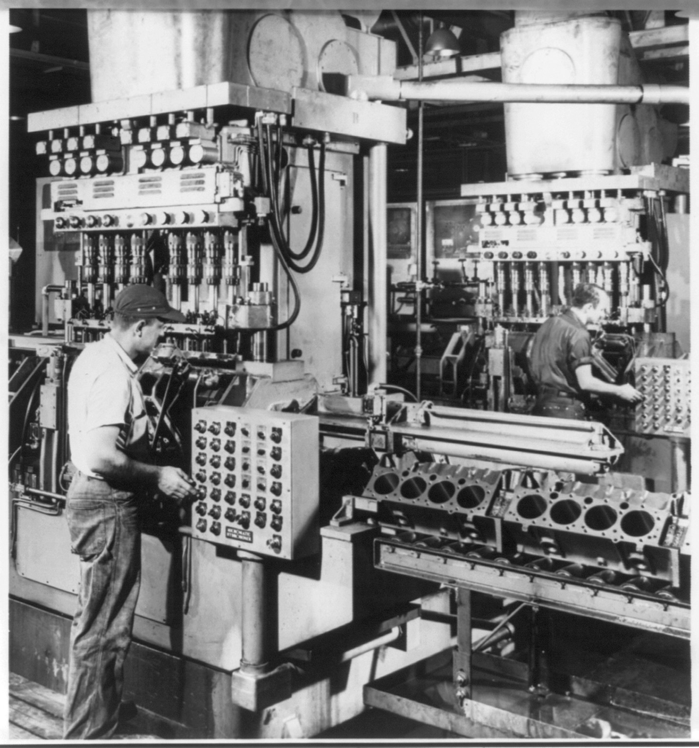 [Man operating machine which automatically hones the bores of Chevrolet V-8 engines in the Chevrolet engine plant at Flint, Michigan], 1956 — historic photograph