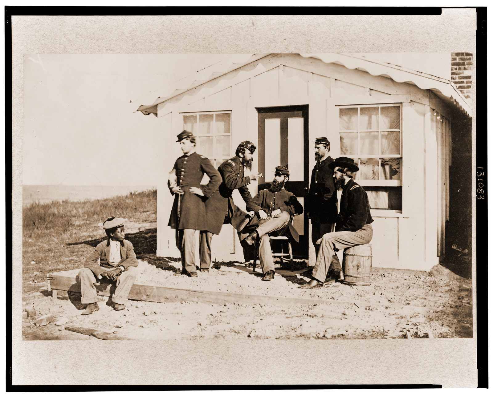 Five Civil War soldiers gathered on dirt porch outside home African American youth, 1861 — historic photograph