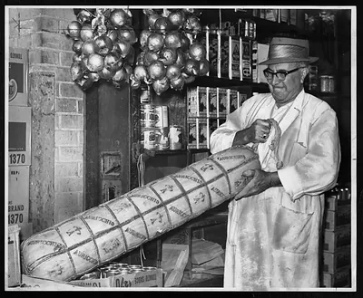 Man holding giant Auricchio provolone cheese in a grocery