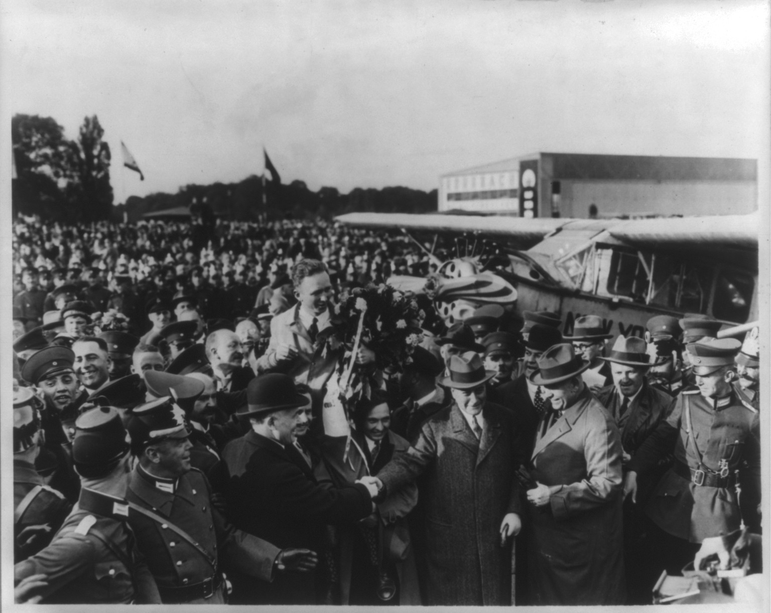 [Clarence Duncan Chamberlin, 1893- , being carried on the shoulders of the crowd upon his arrival in Germany, holding a bouquet of flowers, facing right, June 6, 1927] — historic photograph