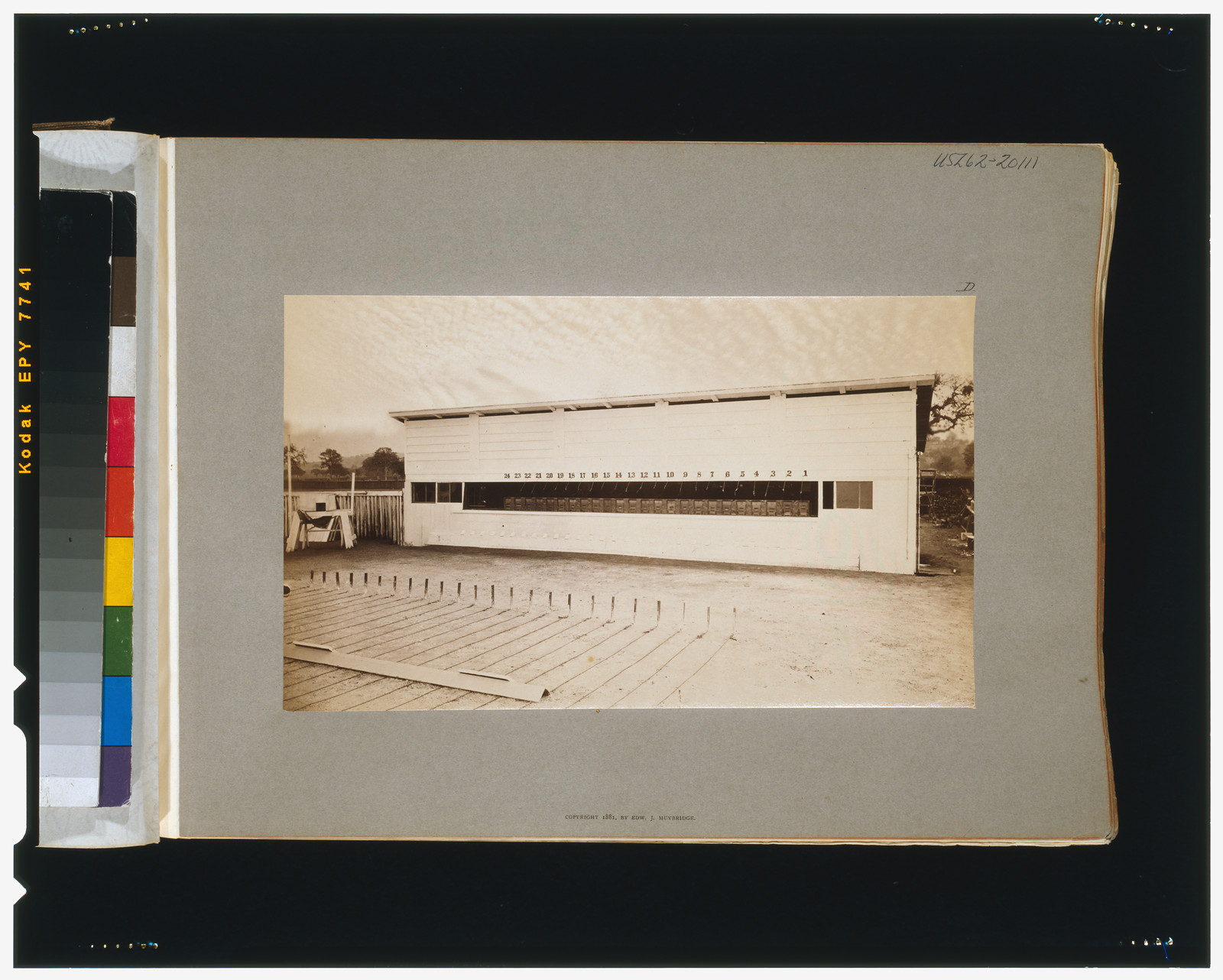 Photograph of a long white building with a sloped roof — historic photograph