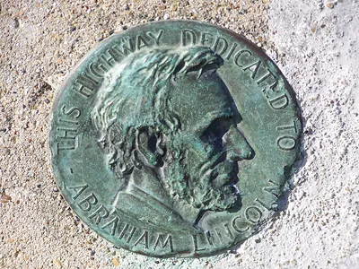 Bronze medallion of Abraham Lincoln on highway dedication marker