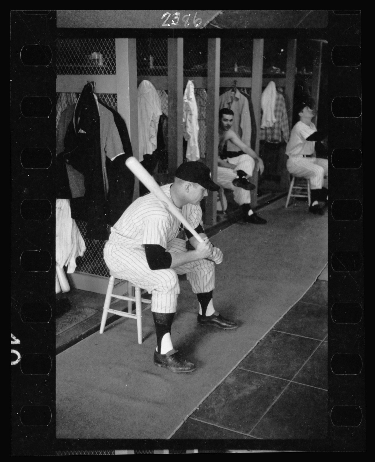 [Mickey Mantle, New York Yankee baseball player, in uniform, sitting in locker room holding a bat] / Marvin E. Newman. — historic photograph